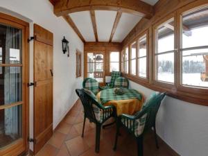 een eetkamer met een tafel, stoelen en ramen bij Holiday apartment carefree in Inzell