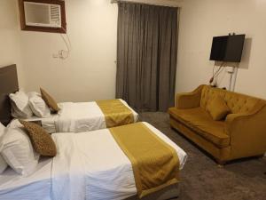 Habitación de hotel con 2 camas y sofá en واحة المدينة 2 en Medina