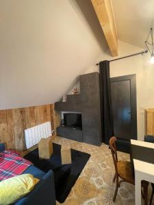 a living room with a bed and a tv at REFUGE DU CAP in Saint-Lary-Soulan