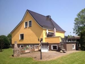 a yellow house with a playground in front of it at Holiday home Baltic Sea Dream in Zudar