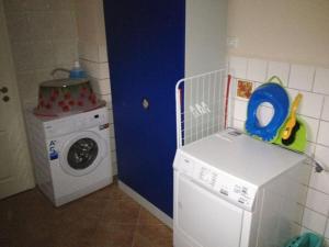 a laundry room with a washing machine and a blue door at Holiday home Baltic Sea Dream in Zudar