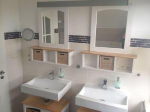 a bathroom with two sinks and a mirror at Holiday home Baltic Sea Dream in Zudar +23 photos