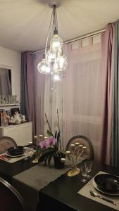 a dining room with a table and a chandelier at IL & DG Immobilier in Saint-Denis