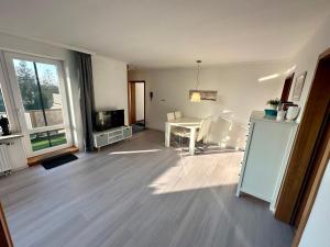 uma sala de estar vazia com uma mesa e uma televisão em Haus Elbe Wohnung #15 - 10 min zu Fuß zum Strand em Cuxhaven
