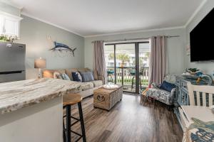 uma cozinha e sala de estar com um sofá e uma mesa em Casa Del Marlin - Your Beach Retreat on Galveston Island, TX em Galveston