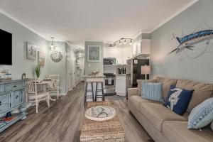 a living room with a couch and a kitchen at Casa Del Marlin - Your Beach Retreat on Galveston Island, TX in Galveston