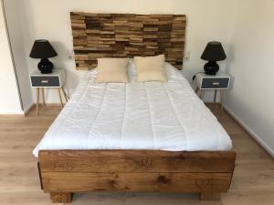 a bedroom with a large bed with two night stands at Maison de caractère proche centre ville et termes in Bourbonne-les-Bains