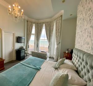 a bedroom with a bed with a view of the ocean at East Beach Hotel in Eastbourne