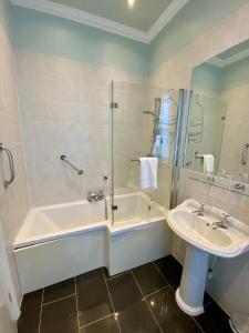 La salle de bains est pourvue d'une baignoire, d'un lavabo et d'une douche. dans l'établissement East Beach Hotel, à Eastbourne