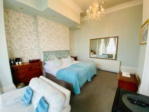a bedroom with two beds and a mirror at East Beach Hotel in Eastbourne