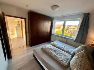 ein Schlafzimmer mit einem Bett und einem großen Fenster in der Unterkunft Haus Elbe Wohnung #15 - 10 min zu Fuß zum Strand in Cuxhaven