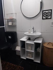 La salle de bains est pourvue d'un lavabo et d'un miroir. dans l'établissement PdLuz Casa Completo e Confortável, à São Paulo