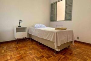 sypialnia z łóżkiem i stołem z lampką w obiekcie Apartamento Confortável e Espaçoso UEM EL06 w mieście Maringá