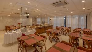 a restaurant with wooden tables and chairs and a buffet at Lizon Curitiba Hotel in Curitiba