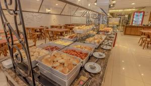 a buffet of food on a counter in a restaurant at Lizon Curitiba Hotel in Curitiba