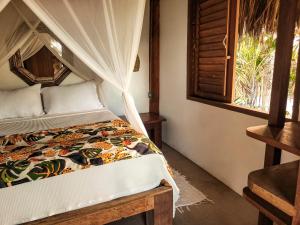 a bedroom with a bed with a canopy at Pousada Flor Do Mar in Caraíva