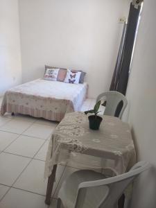 Habitación pequeña con mesa y cama en Linda suite privativa no francês demais cômodos compartilhados, en Marechal Deodoro