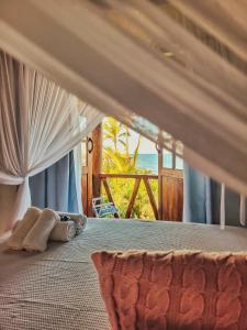 a bedroom with a bed with a view of the ocean at Pousada Flor Do Mar in Caraíva