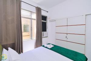 1 dormitorio con cama y ventana en Sala e quarto silencioso para 5 pessoas en Río de Janeiro