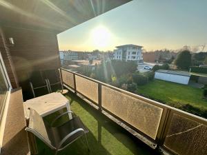 einen Balkon mit einem Tisch und Stühlen sowie Stadtblick in der Unterkunft Haus Elbe Wohnung #15 - 10 min zu Fuß zum Strand in Cuxhaven