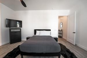 1 dormitorio con 1 cama y TV de pantalla plana en Skylit Townhome in Arcadia, Close to everything Phoenix and Scottsdale, en Phoenix