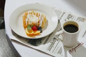 a plate of food with fruit and a cup of coffee at Alexander Inn in Philadelphia