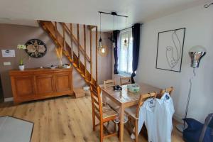 a dining room with a wooden table and a staircase at Le Duplex in Monchy-Saint-Éloi