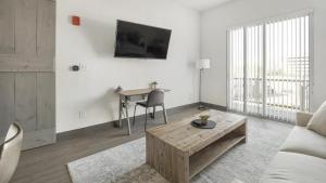 een witte woonkamer met een tafel en een bank bij Landing Modern Apartment with Amazing Amenities (ID1400X813) in Birmingham