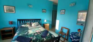 Dormitorio azul con cama y pared azul en Casa Gaia en Serpins