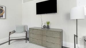 Pokój z komodą, krzesłem i telewizorem w obiekcie Landing - Modern Apartment with Amazing Amenities (ID7691X05) w mieście Richmond
