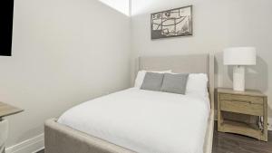 sypialnia z białym łóżkiem i lampką w obiekcie Landing - Modern Apartment with Amazing Amenities (ID7691X05) w mieście Richmond