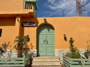 a house with a green door and stairs in front at Beit Reihana in Dahab