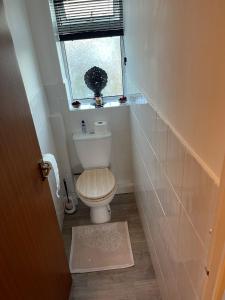 a small bathroom with a toilet and a window at 3 Cosy private rooms in house near Safari Park & Hospital 
