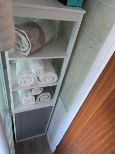 a towel rack with rolled towels in a bathroom at 3 Cosy private rooms in house near Safari Park & Hospital 