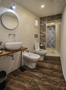a bathroom with a sink and a toilet and a mirror at Lustru Apartment in Catania