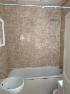 a bathroom with a bath tub and a sink at 3 Bedroom Apartment, Flat in London in Forest Hill