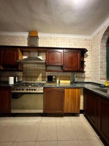a kitchen with wooden cabinets and a stove top oven at Hello sunshine in Dar es Salaam