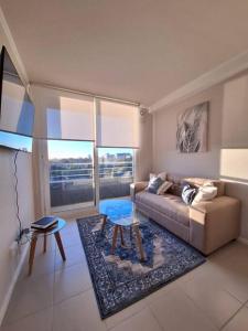 een woonkamer met een bank en een tafel bij Apart Total Temuco Centro in Temuco
