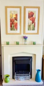 a fireplace with two pictures above it with two vases at Idyllic mobile home in beautiful surroundings in Porchfield