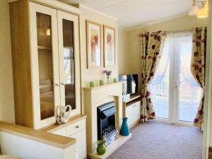 a living room with a fireplace and a window at Idyllic mobile home in beautiful surroundings in Porchfield