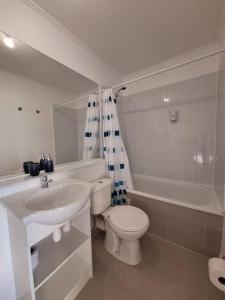 a white bathroom with a sink and a toilet at Apart Total Temuco Centro in Temuco