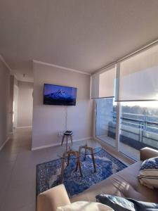 een woonkamer met een bank en een groot raam bij Apart Total Temuco Centro in Temuco