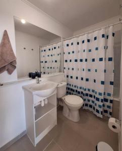 een witte badkamer met een toilet en een wastafel bij Apart Total Temuco Centro in Temuco +30 foto's
