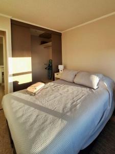 a bedroom with a large bed with two pillows at Apart Total Temuco Centro in Temuco