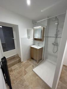a bathroom with a glass shower and a sink at Logement T2 au coeur du village in Gruissan