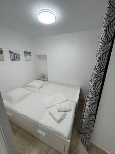 a white bed in a room with a window at Logement T2 au coeur du village in Gruissan