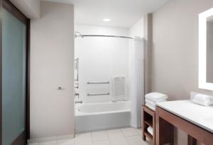 a bathroom with a shower and a bath tub at Courtyard by Marriott Seattle SeaTac Airport in Seattle