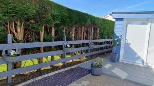 a fence with baskets of flowers and a door at The Beach House in Valley