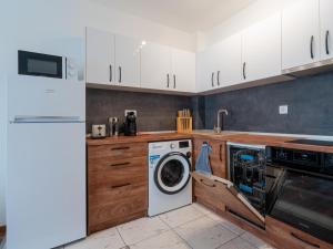 a kitchen with a washing machine and a washer at Apartment Presiyana in Varna City