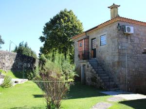 um edifício de pedra com uma escada num quintal em Excellent Cottage in Santa Comba with Communal Pool em Ponte de Lima